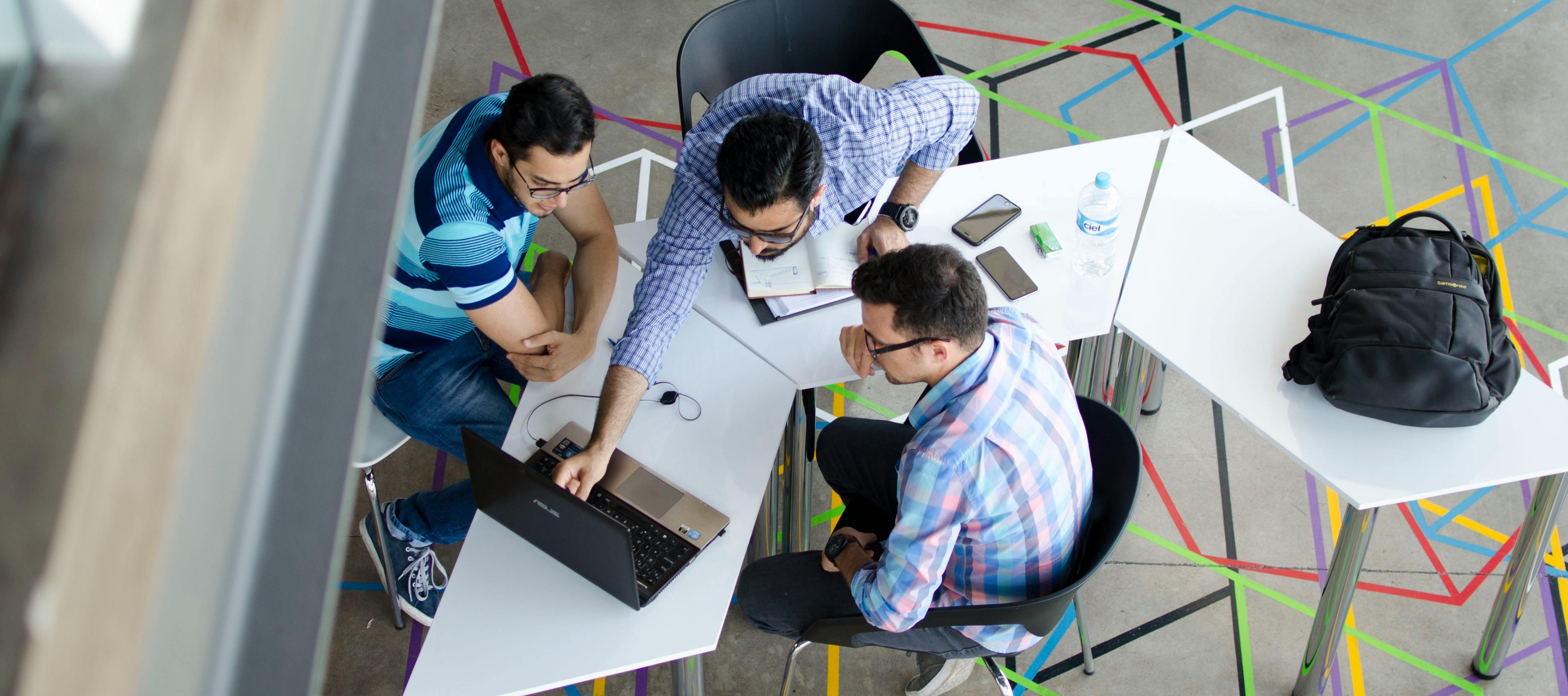 A people working on a zig zag desk having a good time working
